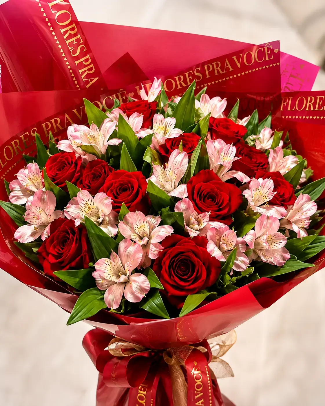 Buquê de rosas vermelhas com flores claras e folhagens