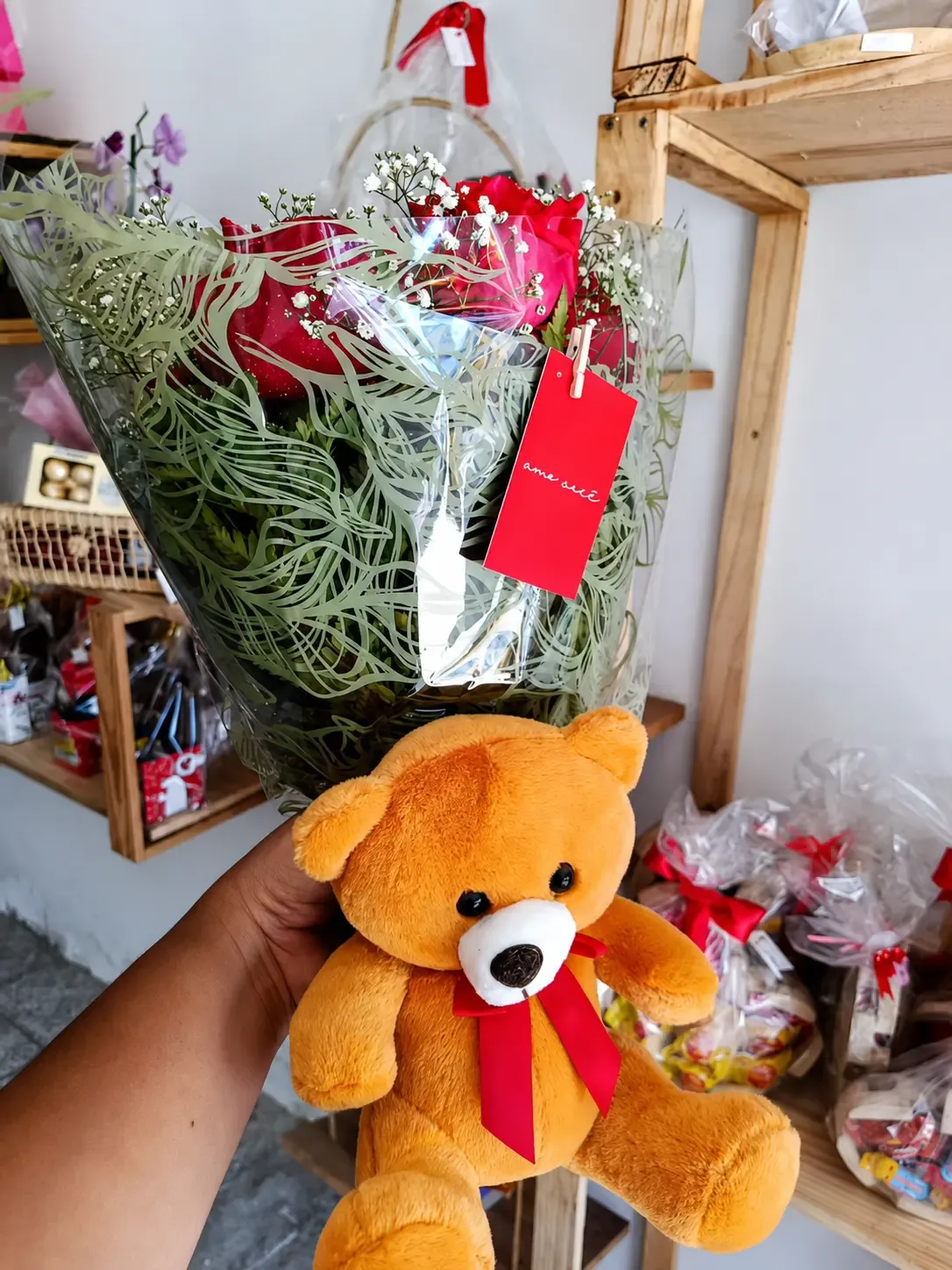 Buquê de rosas vermelhas acompanhado por urso de pelúcia