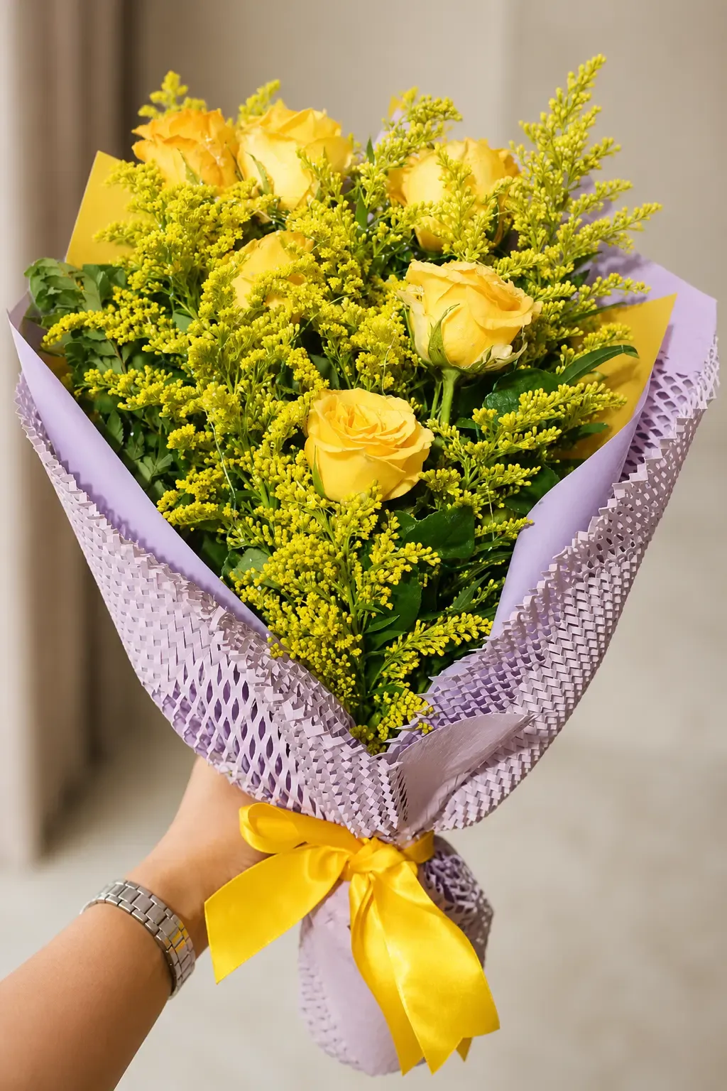 Buquê de rosas amarelas com folhagens e acabamento lilás