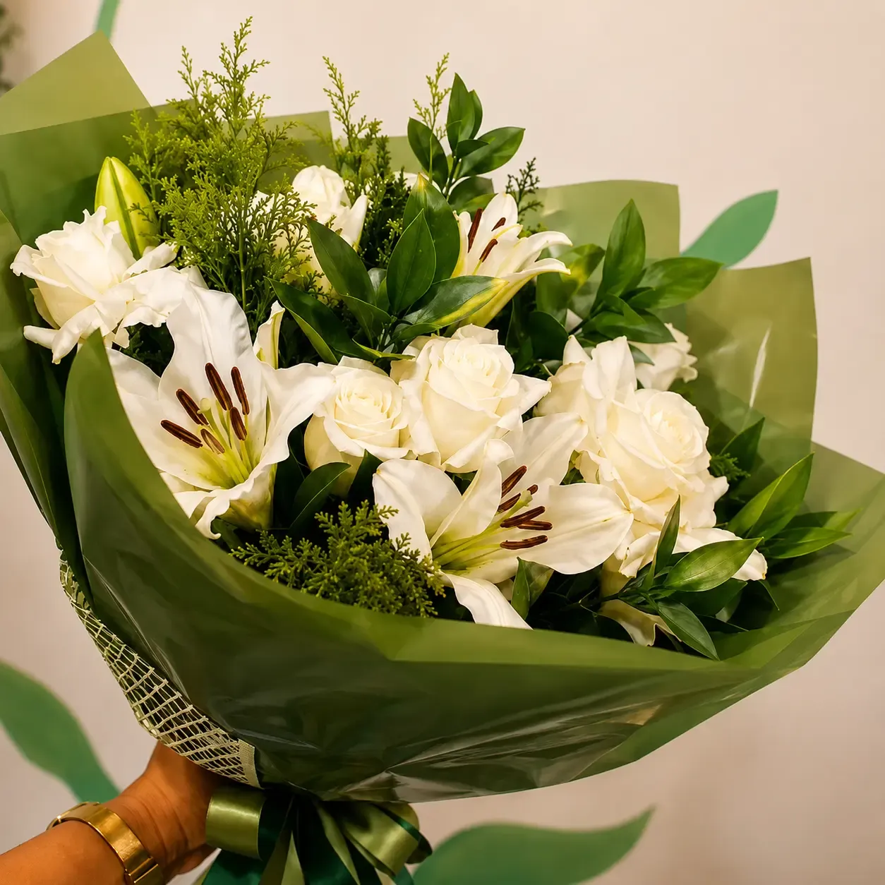 Buquê de rosas brancas e lírios com folhagens verdes